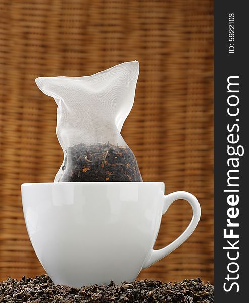 Organic tea in a corn silk tea bag in a white cup.