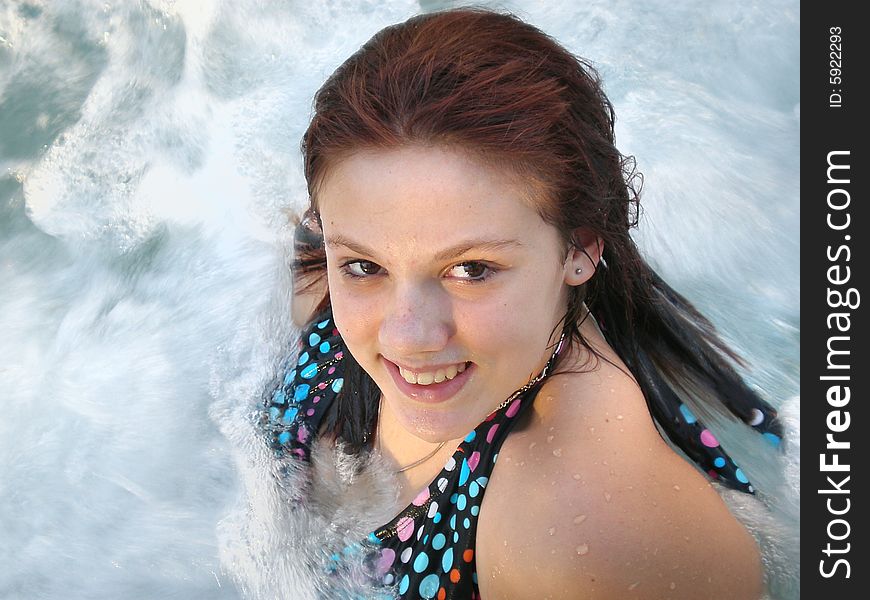 A picture of a white young girl in a polka dot bikini in a jacuzzi.