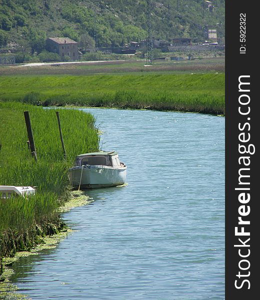 Rasa (Istria - Croatia) postcard: river runs through fertile green fields, boat on the river and a boat wreck in the grass 

*RAW format available