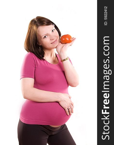 Pretty happy pregnant woman with a tomato against white background