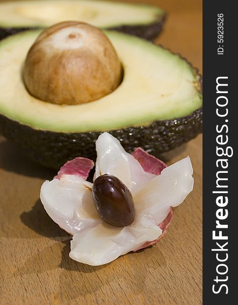 Two half of avocado with seed and litchi. Two half of avocado with seed and litchi