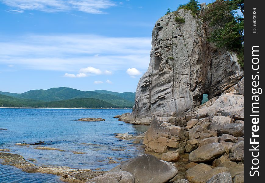 A very small bay among fancy rocks. Seacoast of Petrova island - pearl of nature state reserve Lazovsky. Russian Far East, Primorye. A very small bay among fancy rocks. Seacoast of Petrova island - pearl of nature state reserve Lazovsky. Russian Far East, Primorye.