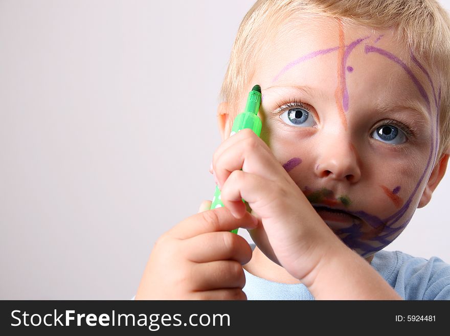 Laughing Toddler playing with colored pens making a mess. Laughing Toddler playing with colored pens making a mess