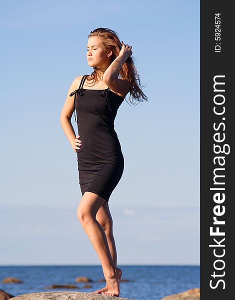 Young lady in black dress enjoying the sun