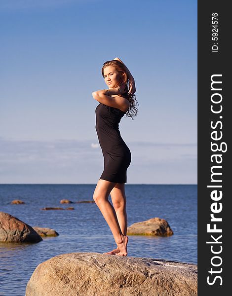 Young lady in black dress touching her hair