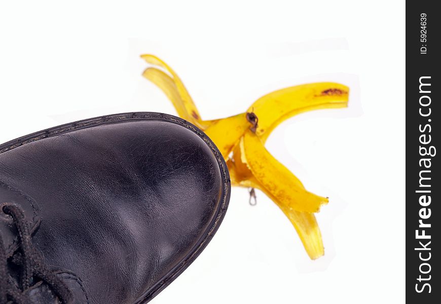 Black shoe stepping on a banana peel top view. Black shoe stepping on a banana peel top view