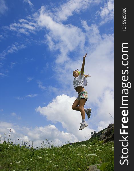The young girl jumps from a rock. The Alpine meadows. Abhasia. The young girl jumps from a rock. The Alpine meadows. Abhasia.