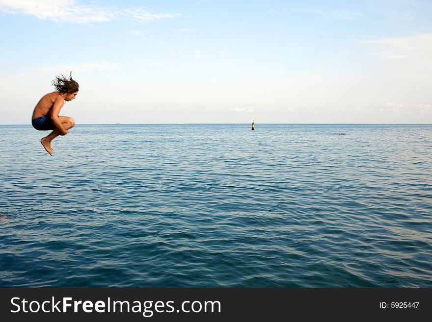 The man jumping in water from a pier