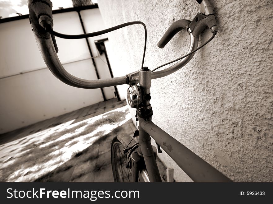 An old bicycle leant by a wall