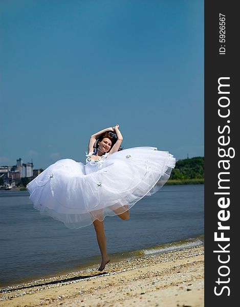 Bride jumping on a sandy beach. Bride jumping on a sandy beach