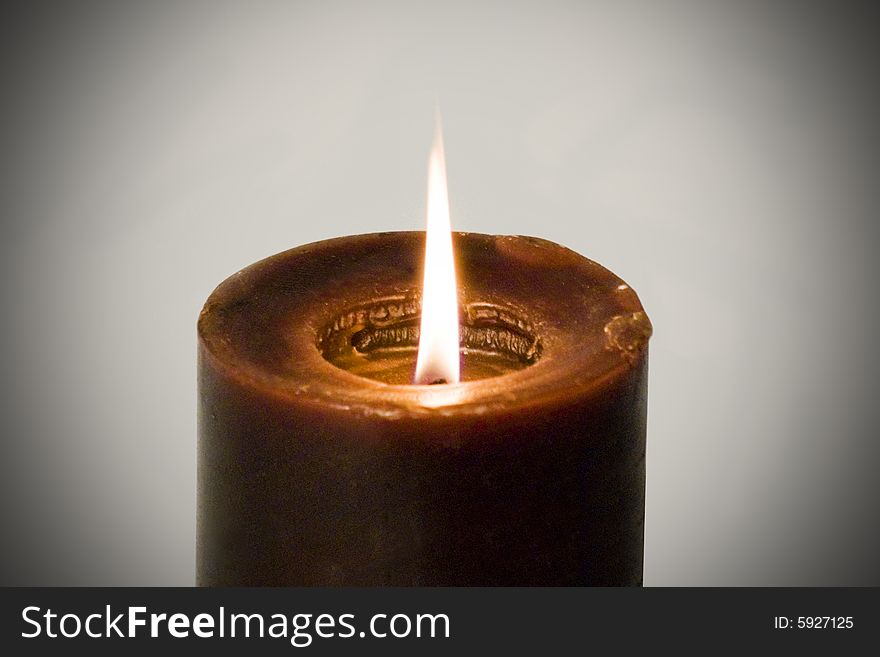 A candle burning and isolated on a dark background. A candle burning and isolated on a dark background