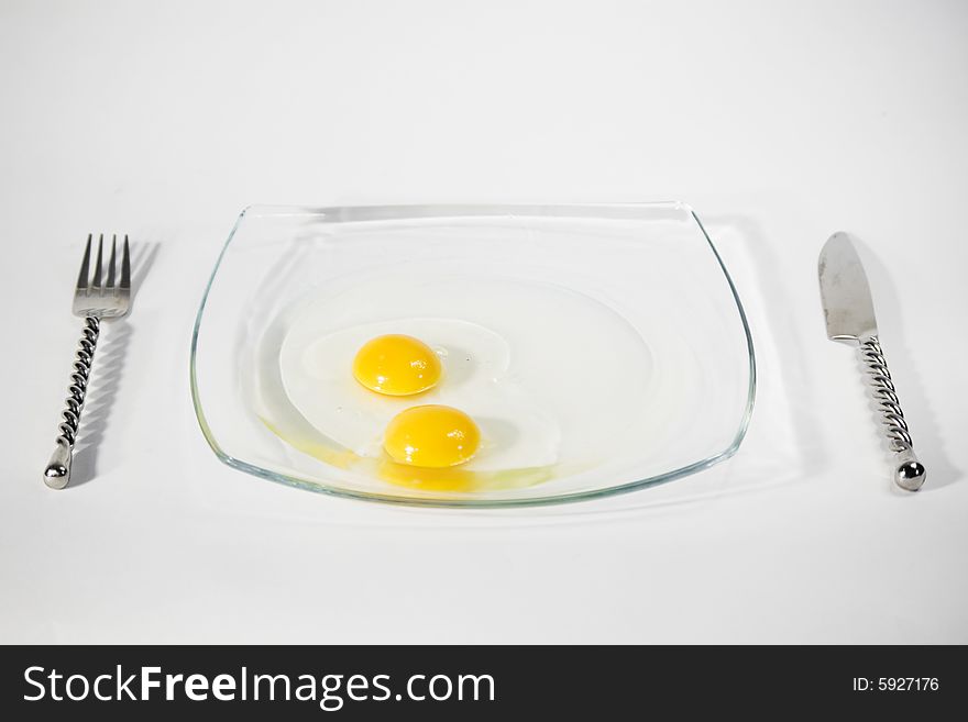 Two raw egg yolk on a plate and isolated on a white background. Two raw egg yolk on a plate and isolated on a white background