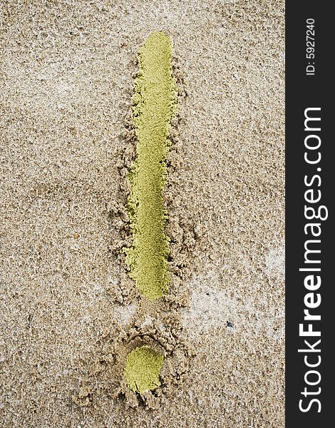 Light yellow exclamation mark on fine sand. Light yellow exclamation mark on fine sand