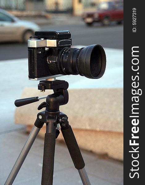A black reflex camera on a support. A black reflex camera on a support