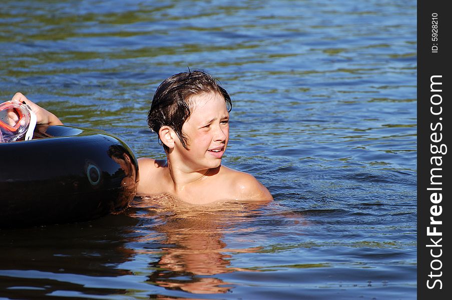 The portrait of a boy with a tube in a lake. The portrait of a boy with a tube in a lake.