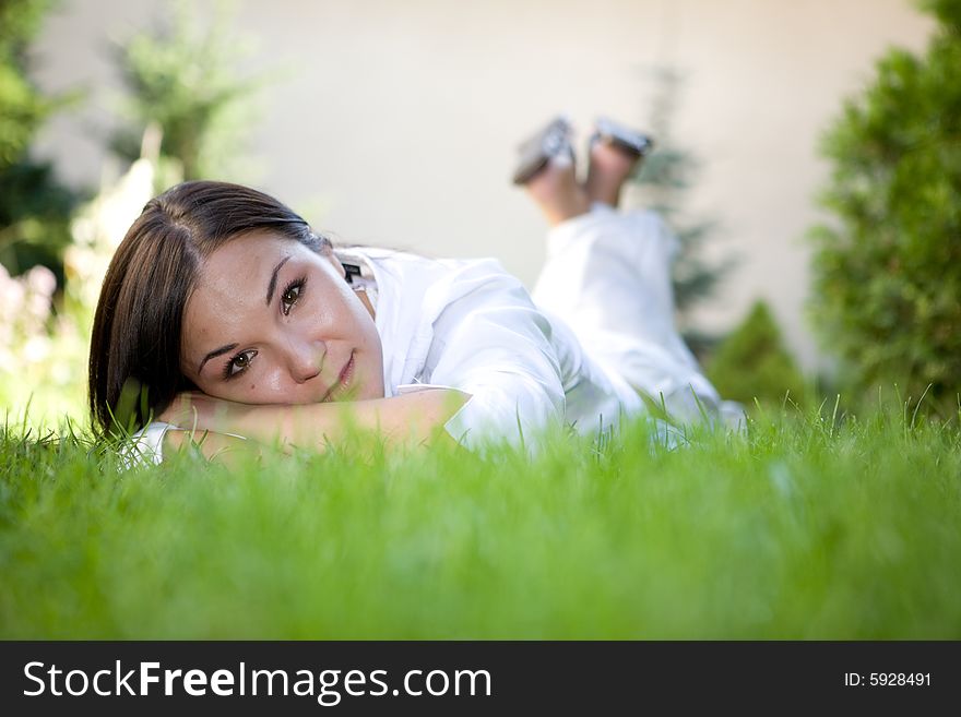 Happy brunette woman lying on grass. Happy brunette woman lying on grass