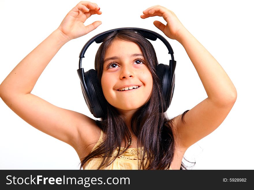 8 year old girl listening to music in big headphones. 8 year old girl listening to music in big headphones