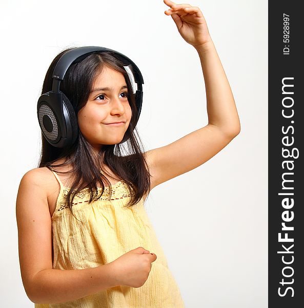 8 year old girl listening to music in big headphones. 8 year old girl listening to music in big headphones