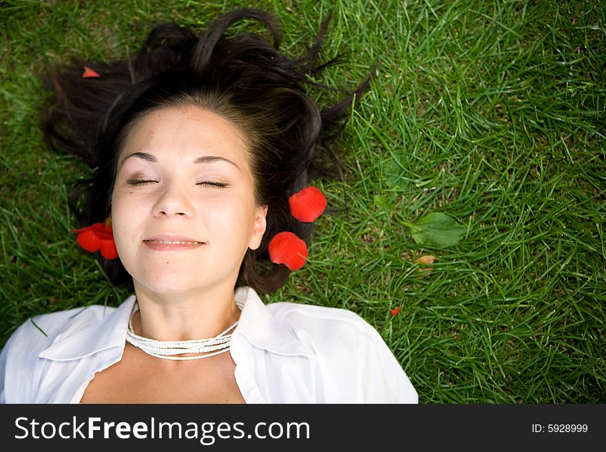 Happy brunette woman lying on grass. Happy brunette woman lying on grass