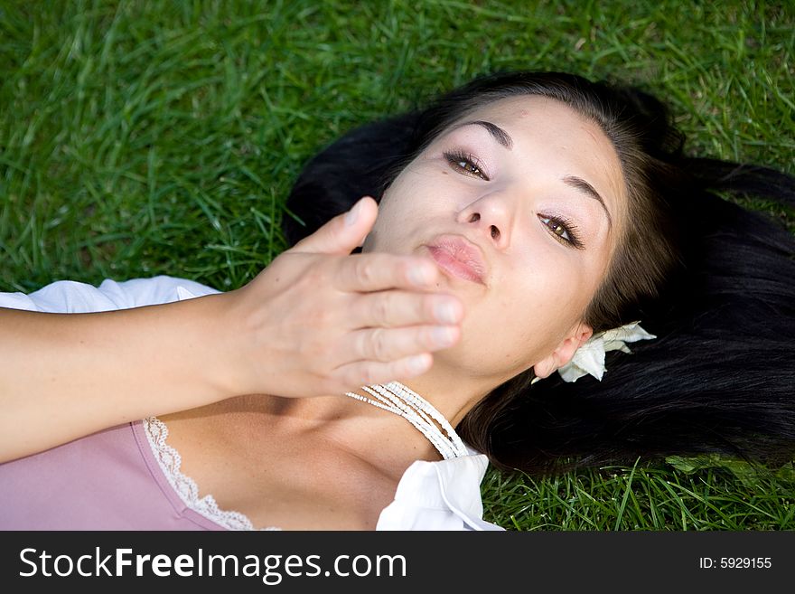 Happy brunette woman lying on grass. Happy brunette woman lying on grass