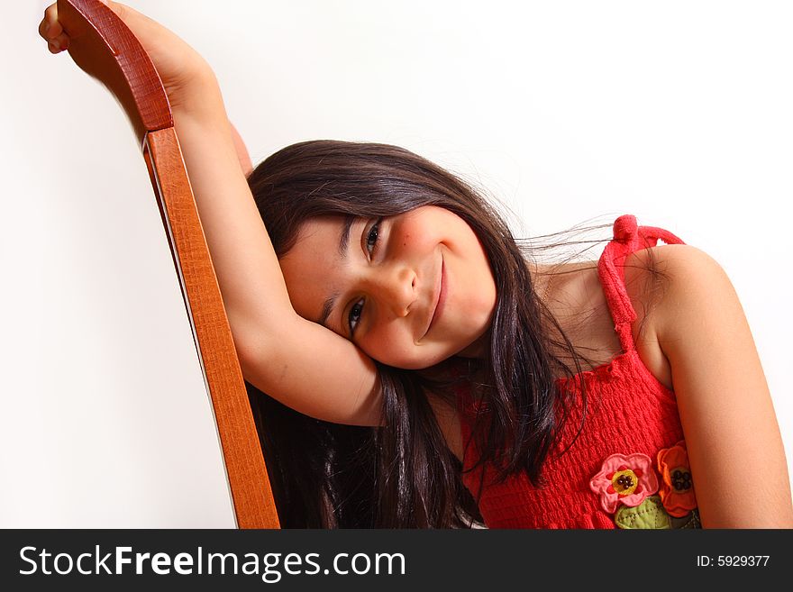 8 year old girl sitting on a chair in red dress. 8 year old girl sitting on a chair in red dress