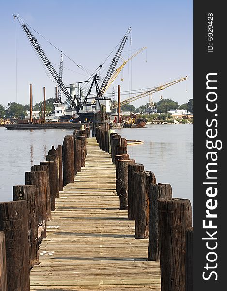 A pier view of floating cranes on the water