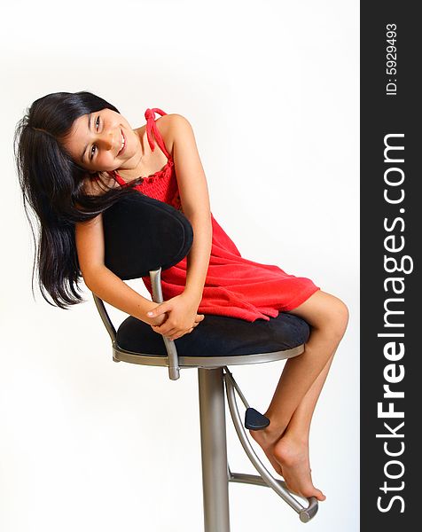 8 year old girl sitting on a chair in red dress. 8 year old girl sitting on a chair in red dress