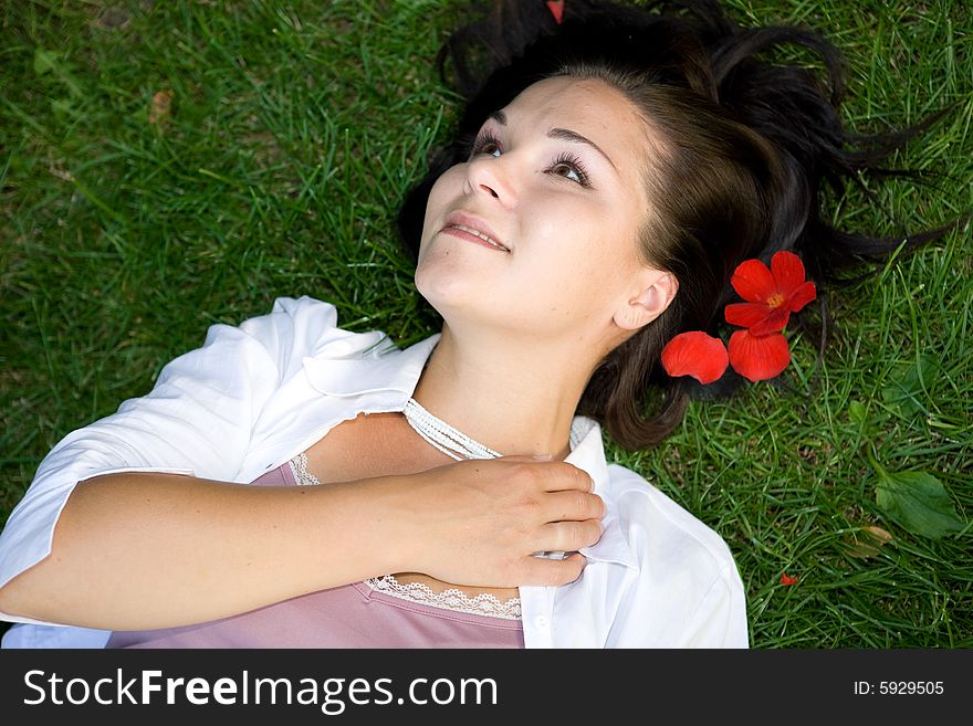 Happy brunette woman lying on grass. Happy brunette woman lying on grass