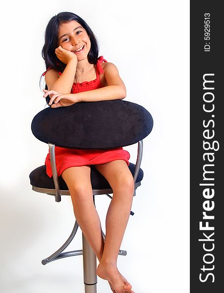 8 year old girl sitting on a chair in red dress. 8 year old girl sitting on a chair in red dress