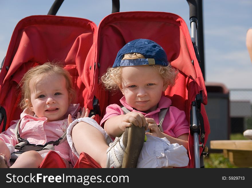 Cute boy and girl in a child carrier