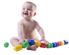 Baby Holding Large Plastic Beads In Lap. Stock Photos Baby Holding Large Plastic Beads In Lap. Stock Photos