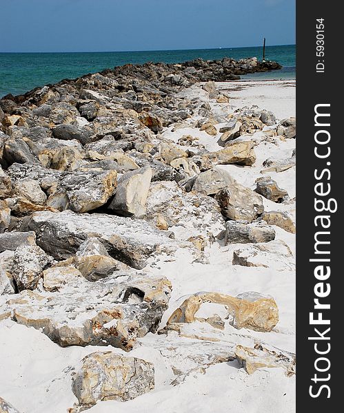 An arrangement of rocks on the beach leading out into the ocean. An arrangement of rocks on the beach leading out into the ocean