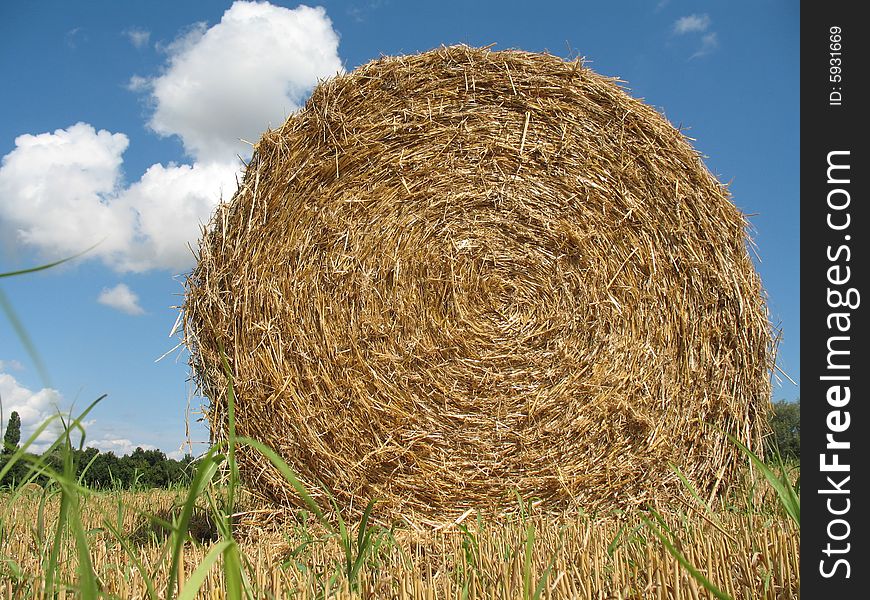 Hay bale with blue sky and white clouds