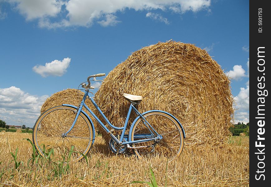 Classic bike, hay bales with blue sky and white clouds. Classic bike, hay bales with blue sky and white clouds