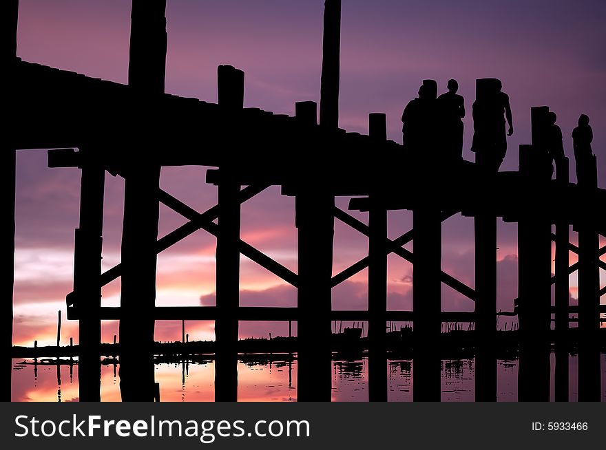 Myanmar, Amarapura, U Bein bridge; stunning sundown at the U bein bridge; bicycle and men black silhouettes