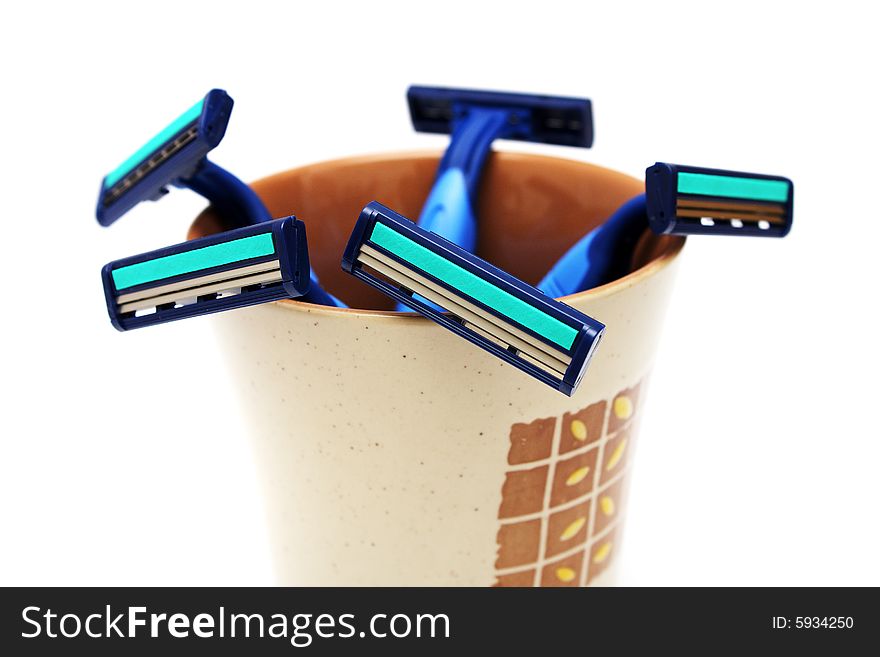 Many blue razor put into a cup on white background. Many blue razor put into a cup on white background.