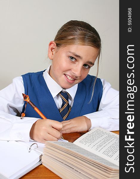 Teenage School girl busy with her homework, wearing uniform