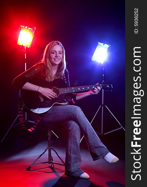 Woman with guitar and stage lights. Woman with guitar and stage lights