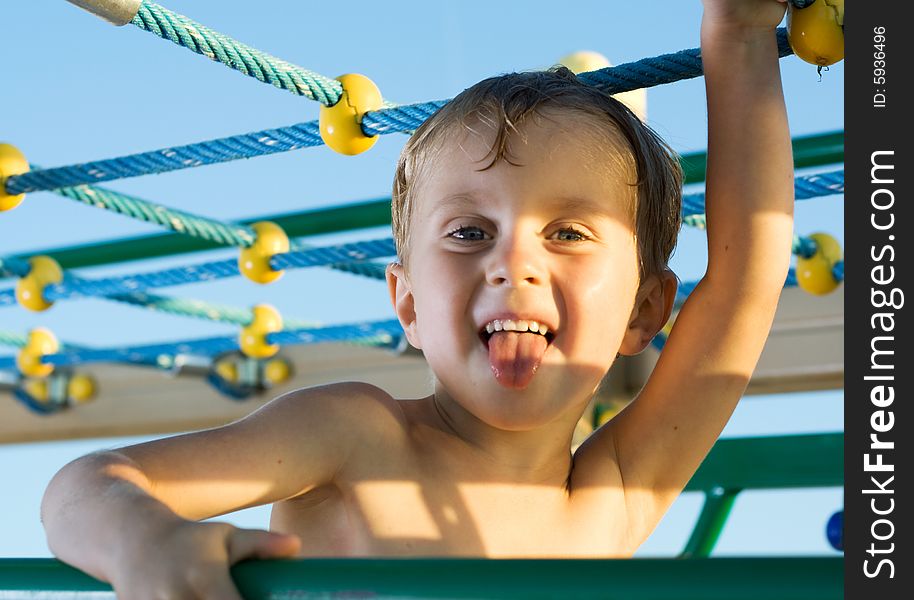 Little boy playing in jungle gym. Little boy playing in jungle gym.