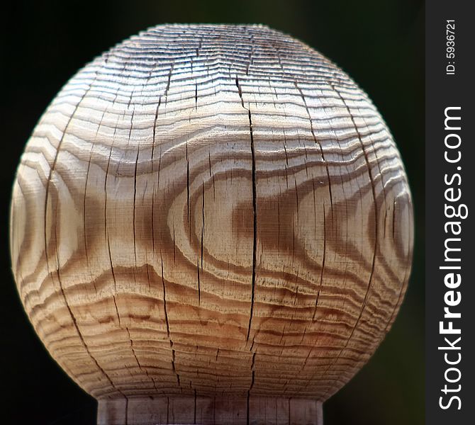 Close view of a grained wood fence post on a dark background. Close view of a grained wood fence post on a dark background