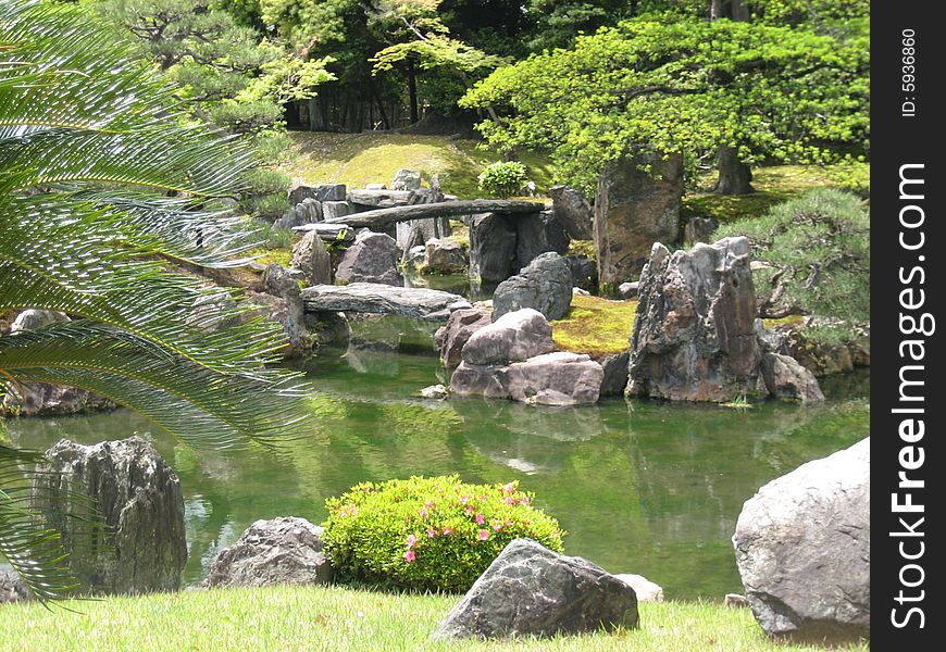 Pond surrounded by greenery and rocks, in a beautiful park Japanese. Pond surrounded by greenery and rocks, in a beautiful park Japanese