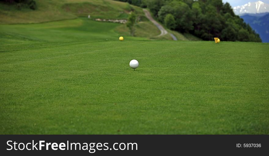 Close view of a golf tee in front of a mountain scenery