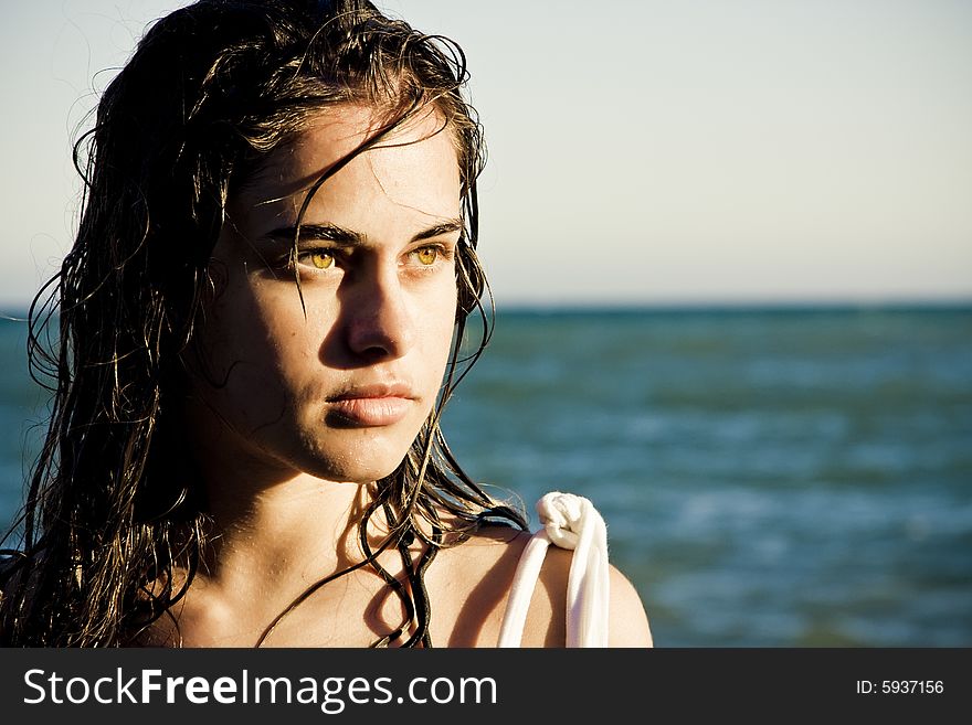 Beautiful green eyed woman portrait with the sea as background. Beautiful green eyed woman portrait with the sea as background.