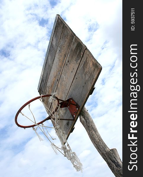 Low angle shoot of very old almost ancient basketball basket on the cloudy weather as background
