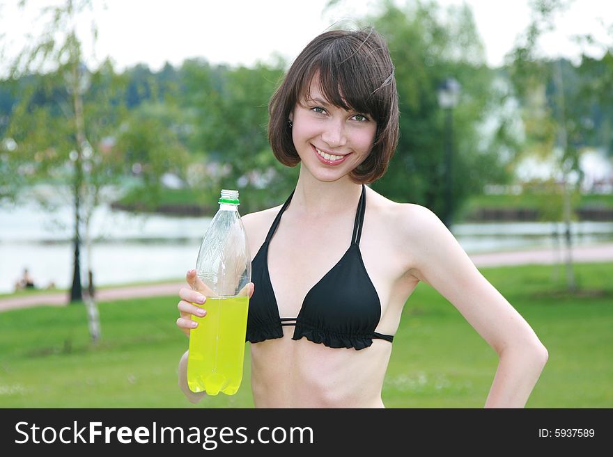 The sports girl in bikini with a bottle of a drink