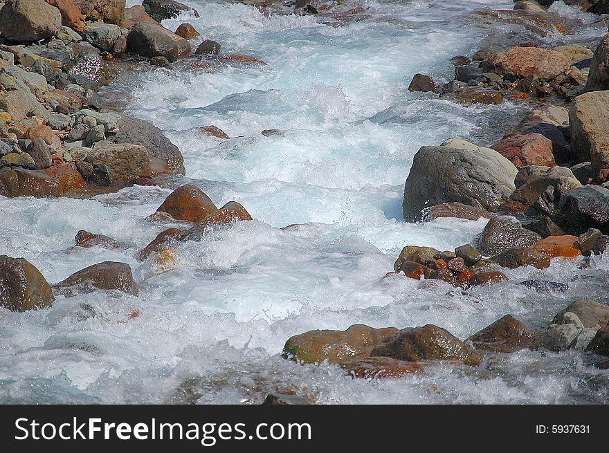 Water flowing over rocks in stream.