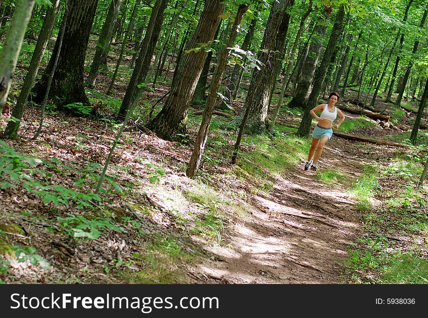 Mature woman running in forest. Mature woman running in forest.