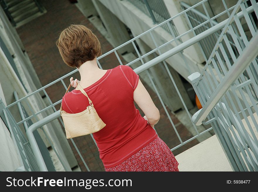 Urban woman walking up stairs.