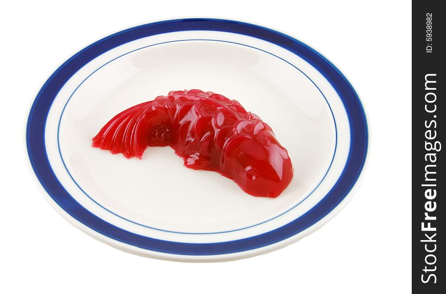 Red fish shaped jello on a plate, isolated in solid white background. Red fish shaped jello on a plate, isolated in solid white background.