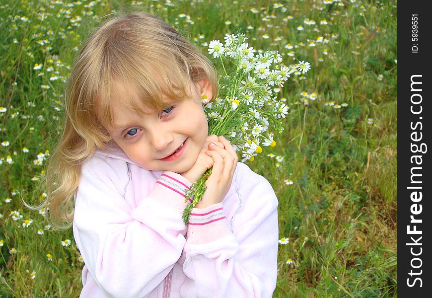 Little girl with the bouquet of camomiles on a glade. Little girl with the bouquet of camomiles on a glade.